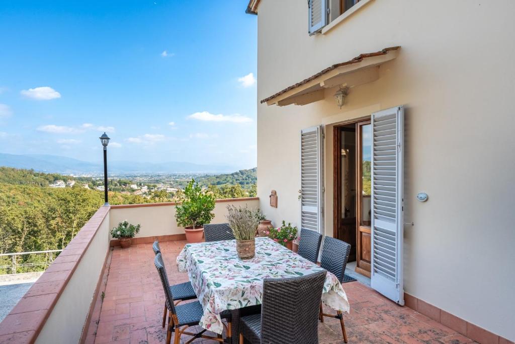 a patio with a table and chairs on a balcony at Villa Adora Holiday Home in Serravalle Pistoiese