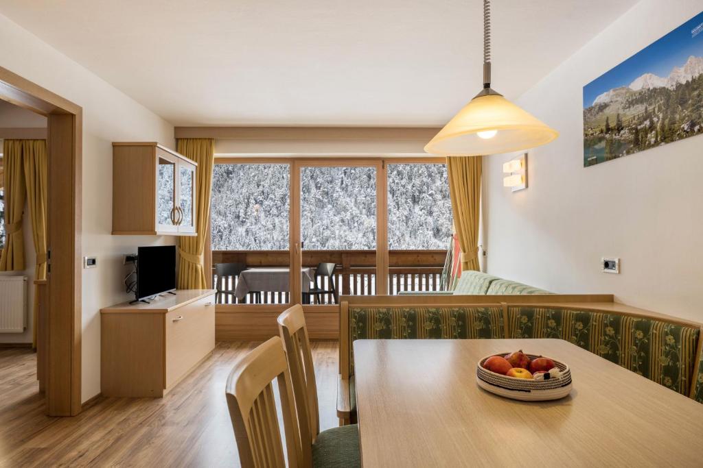 a kitchen and living room with a table with a bowl of fruit at Runcac Apt Pla in San Vigilio Di Marebbe