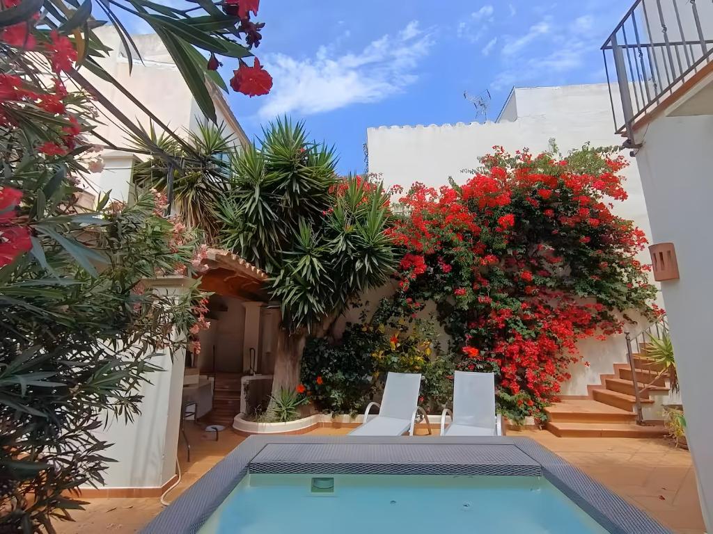 a courtyard with a swimming pool and flowers at Casa Can Alou in Felanitx