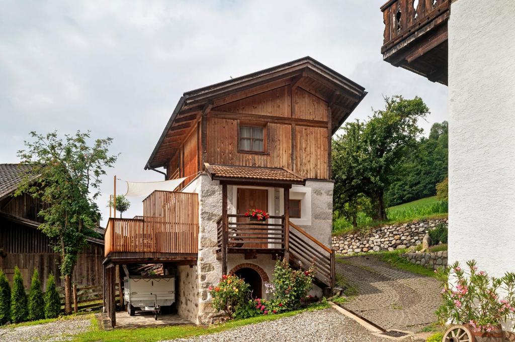 a wooden house with a balcony and a porch at Chalet Stieber in Feldthurns