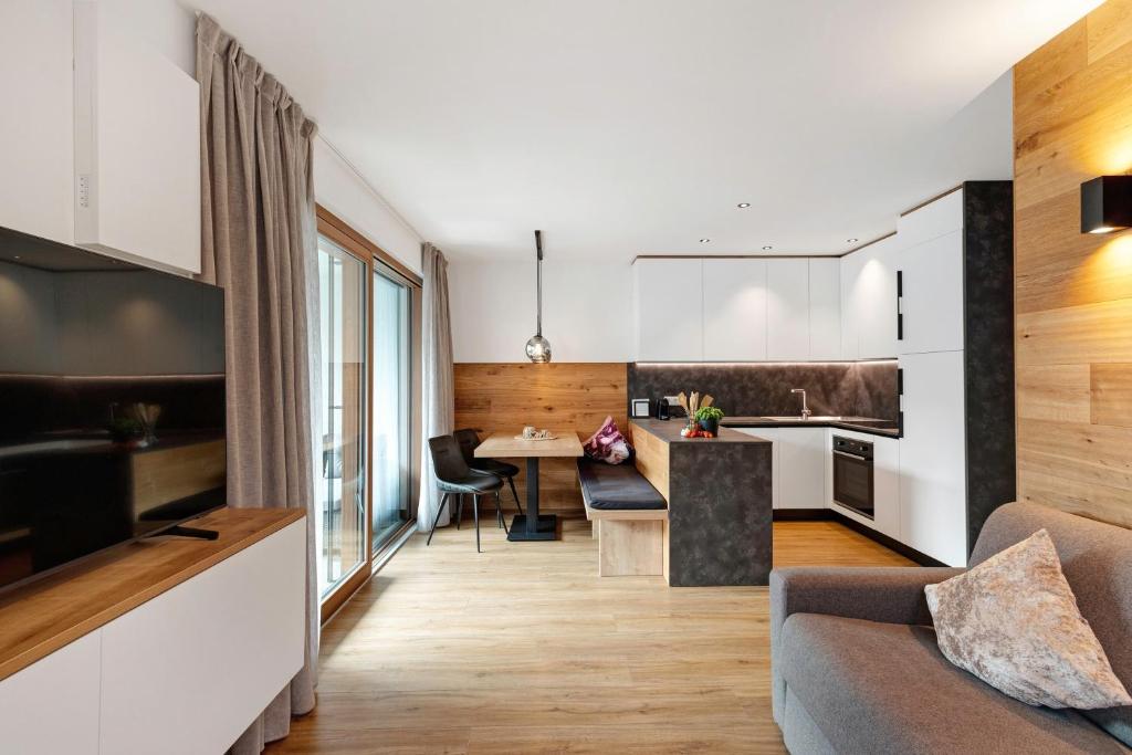 a kitchen and living room with a couch and a table at Appartement Sonnlicht Pfalzen in Falzes