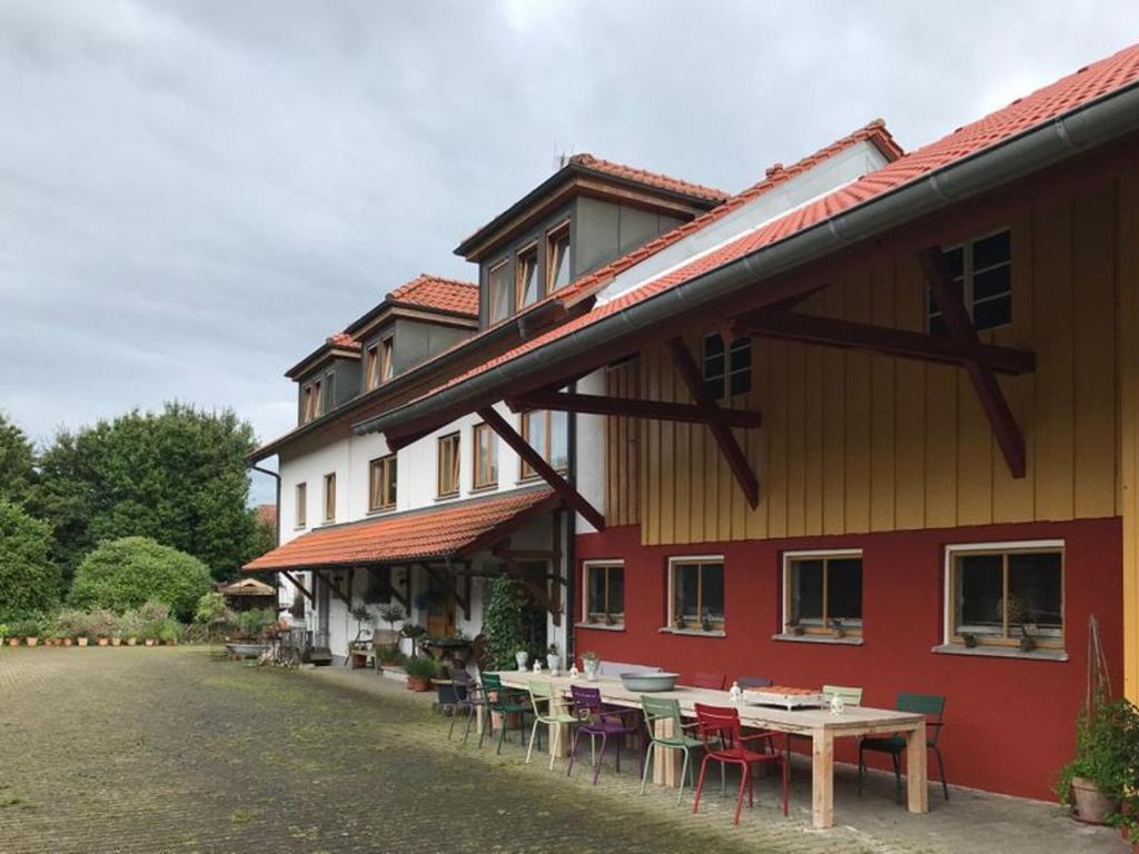 a building with tables and chairs in front of it at Moorwiesenhof in Ostrach