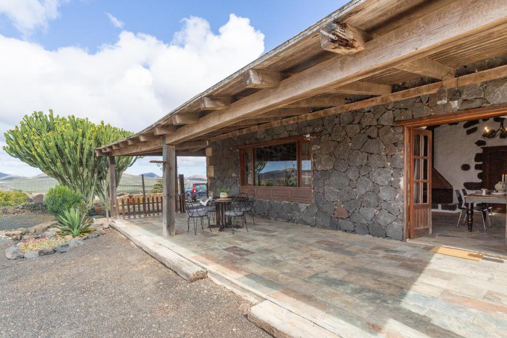 a stone house with a porch and a patio at El Rincón de Guatisea in San Bartolomé
