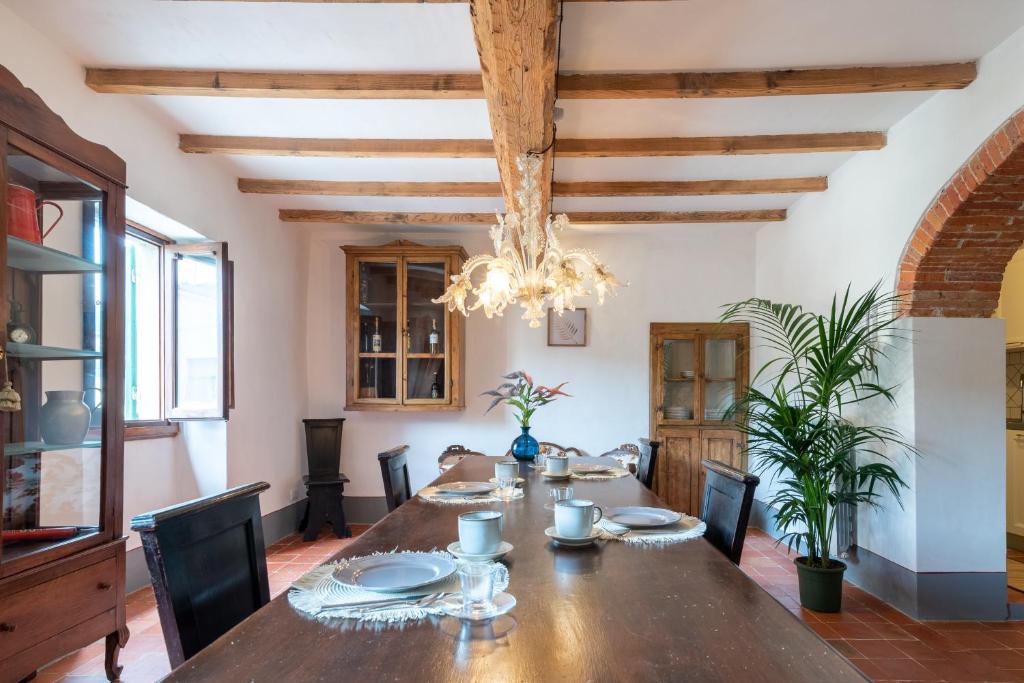 a dining room with a wooden table and a chandelier at Casa Biffoli - Bucine in Bucine