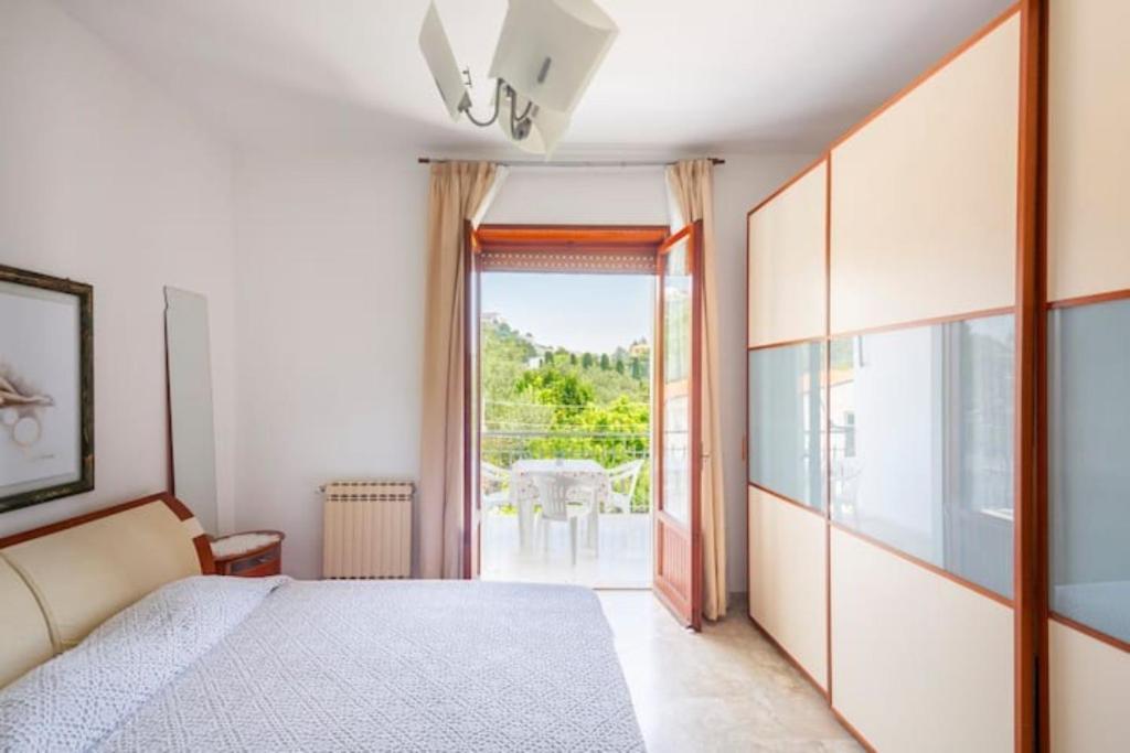 a bedroom with a bed and a door to a balcony at Villa Lucia Guesthouse Minturno in Minturno
