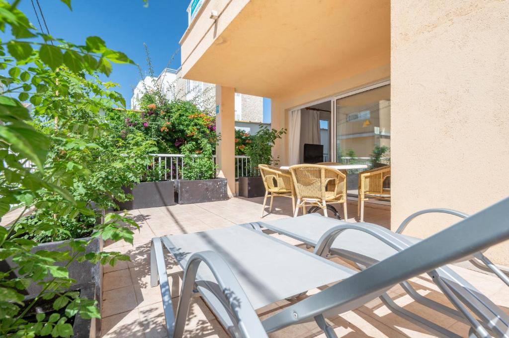 a patio with chairs and a table on a balcony at Talaia Bajos A in Port de Pollensa