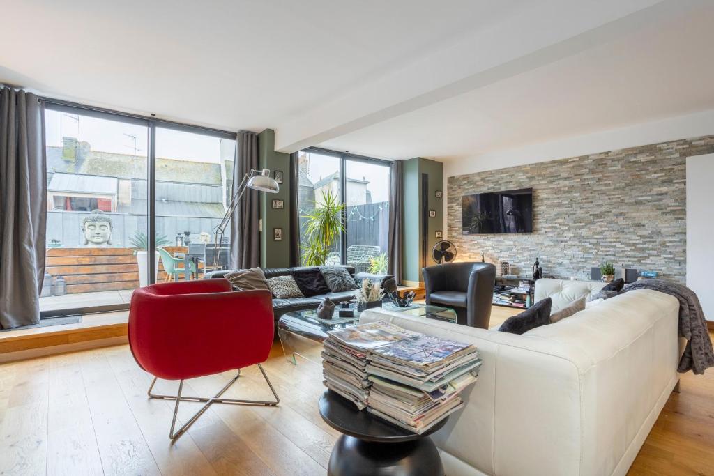 a living room with a white couch and red chairs at Grand Loft plein centre Concarneau in Concarneau