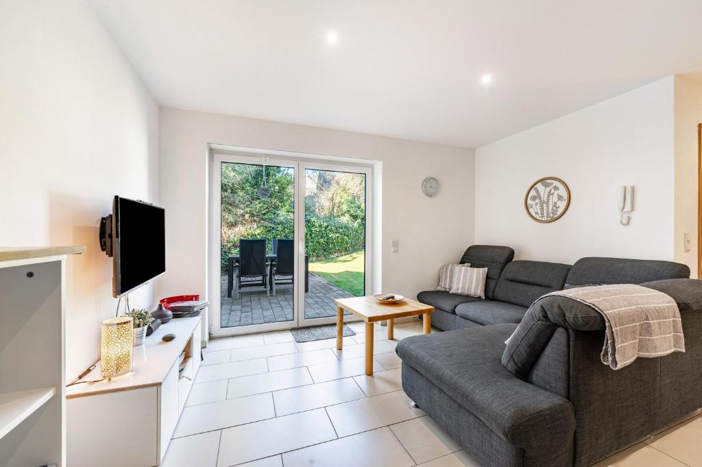 a living room with a couch and a tv at Eifel im Herzen in Hambuch