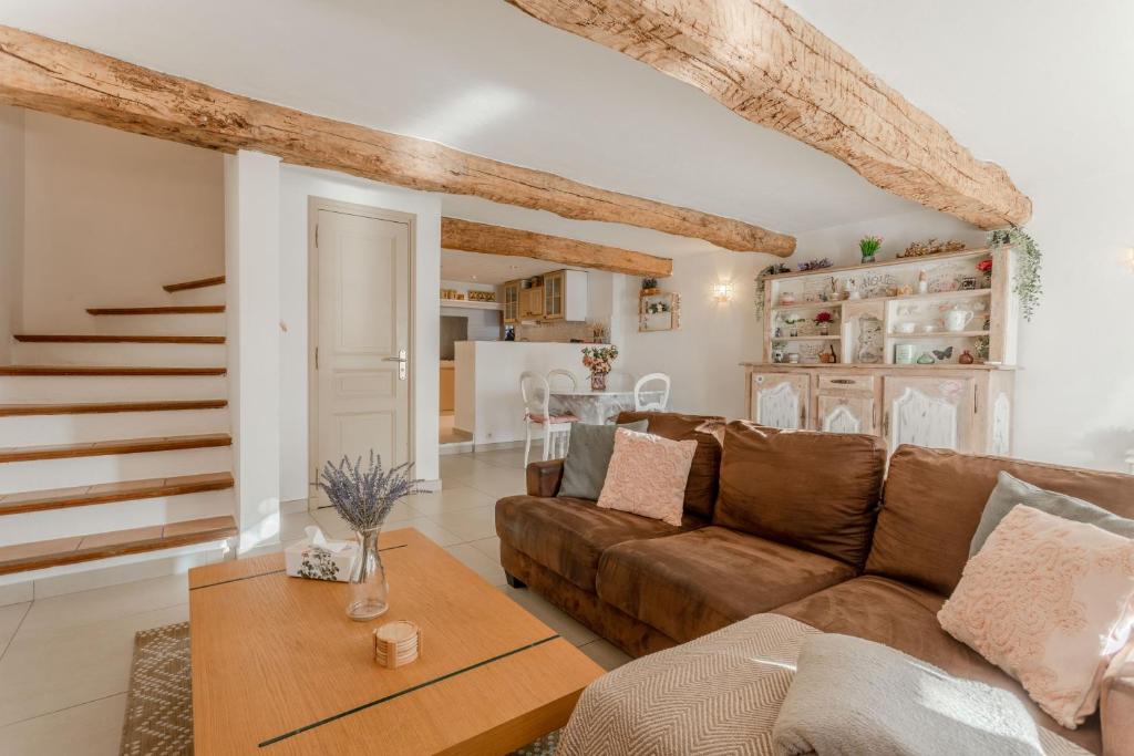 a living room with a brown couch and a table at Maison Sainte-Maxime avec jardin in Le Plan