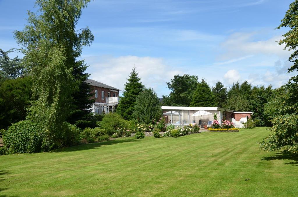 a yard with a house and a large lawn at Ferienhäuser Ella Walter - Efeuhaus in Nordstrand