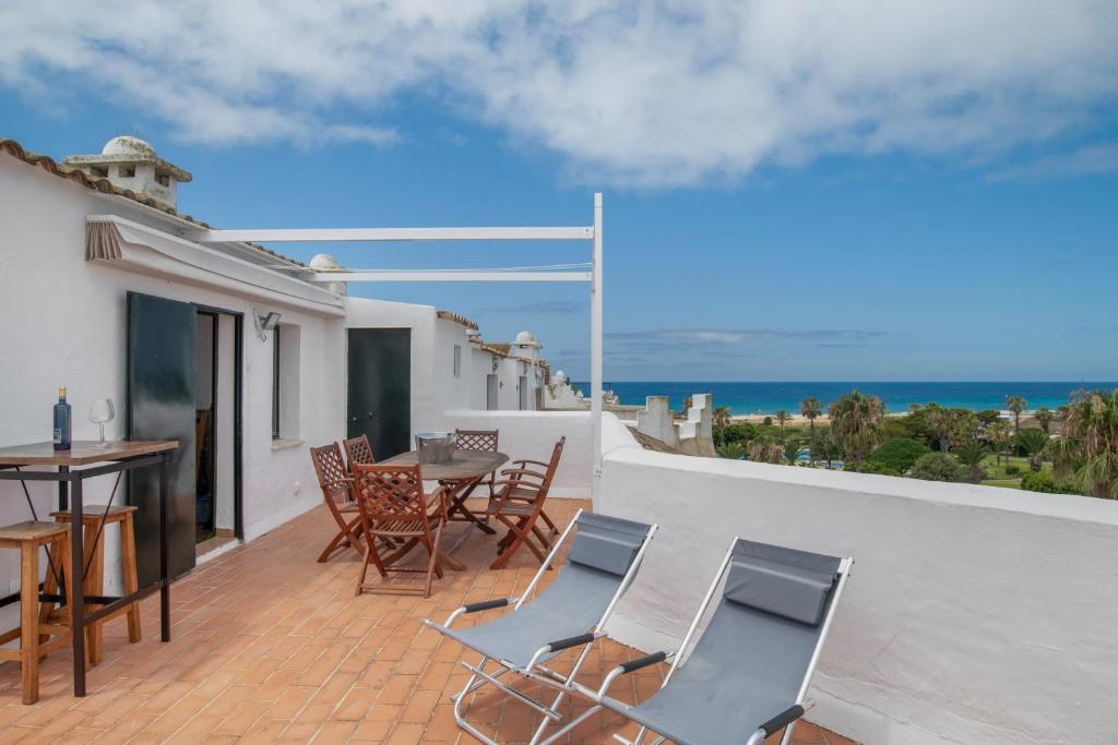 a patio with a table and chairs and the ocean at Bella Vistas in Zahara de los Atunes