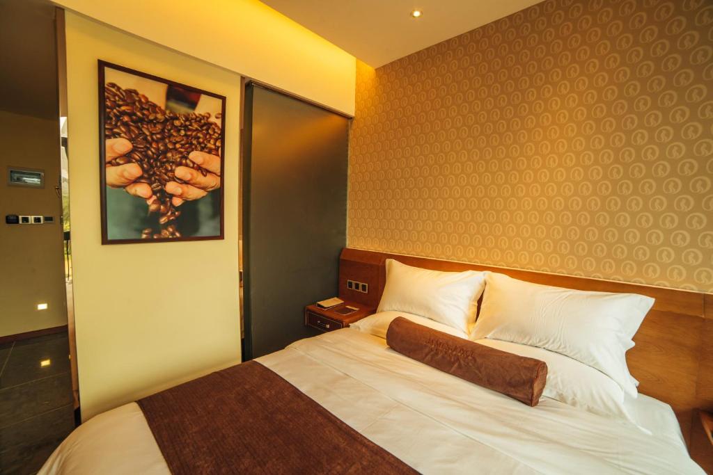 ein Schlafzimmer mit einem Bett und einem Bild an der Wand in der Unterkunft James Joyce Hotel Zhuhai Hengqin Chimelong in Zhuhai