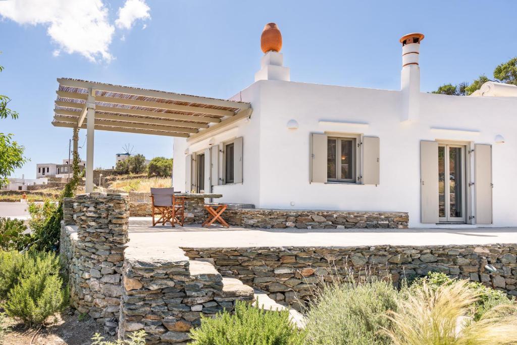 a white house with a stone wall at Black Tower Villa in Apollonia