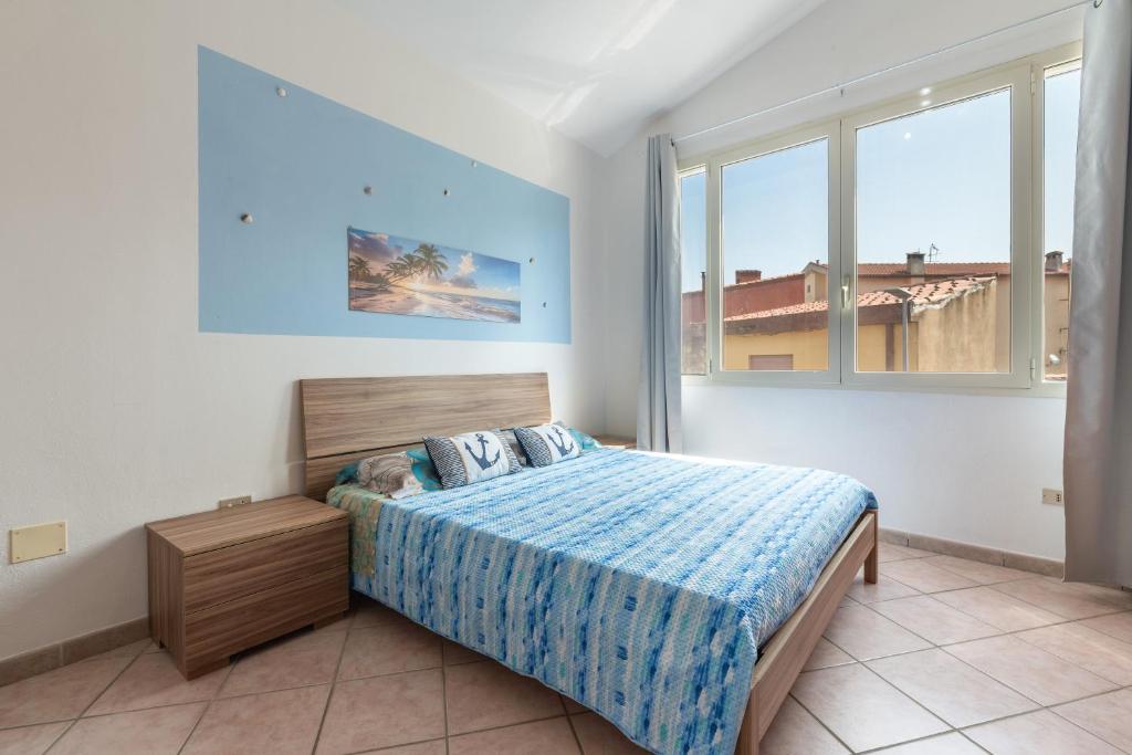 a bedroom with a bed and two windows at Casa Vacanze 4 Venti in Muravera