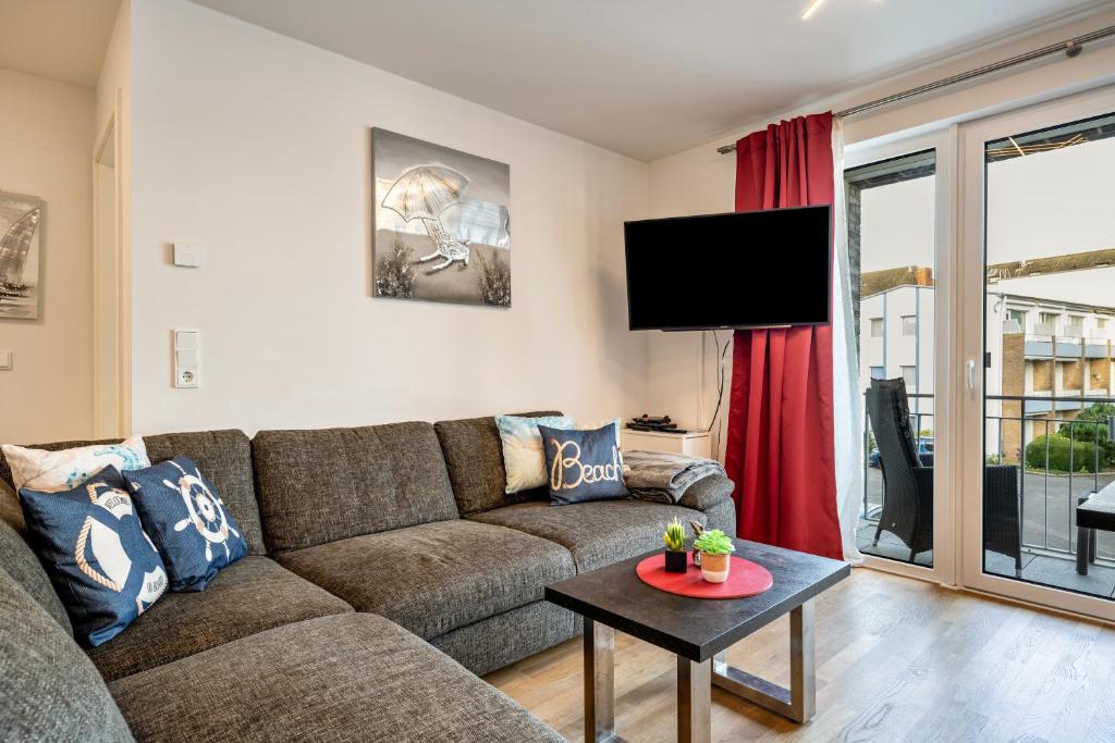 a living room with a couch and a table at Ferienwohnung Moin am Meer in Scharbeutz