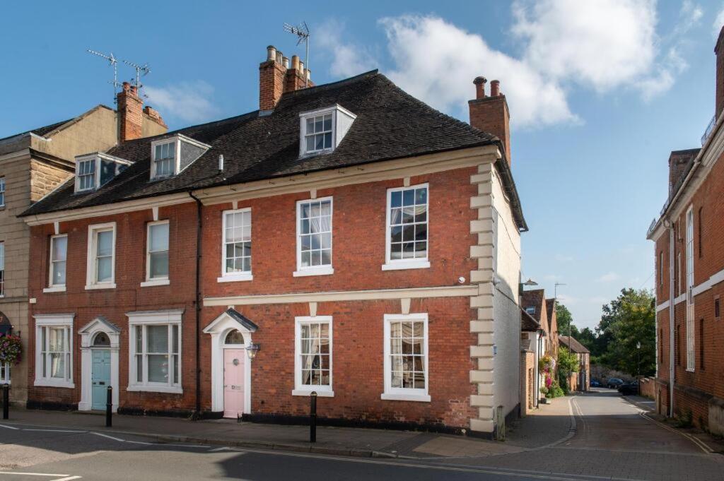a large red brick building with a black roof at Warwick Centre Townhouse Castle views in Warwick