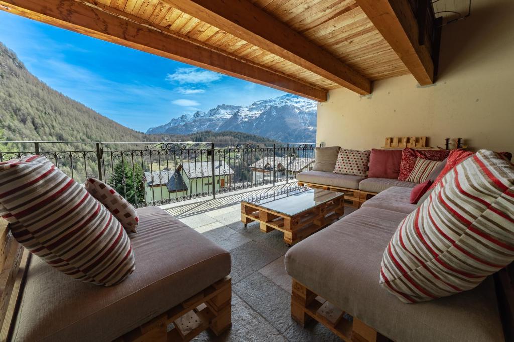 a living room with couches and a view of mountains at Residence Larice Bianco App n2 in Campodolcino
