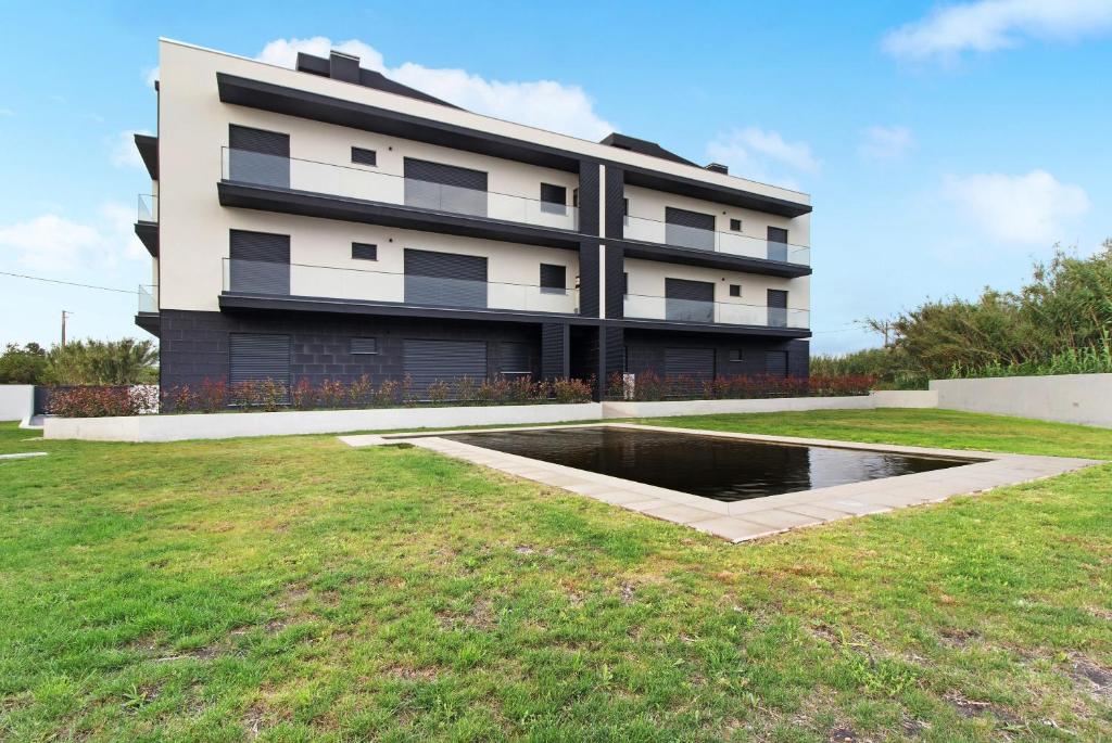 a building with a pond in front of it at Apulia Apartment in Apúlia