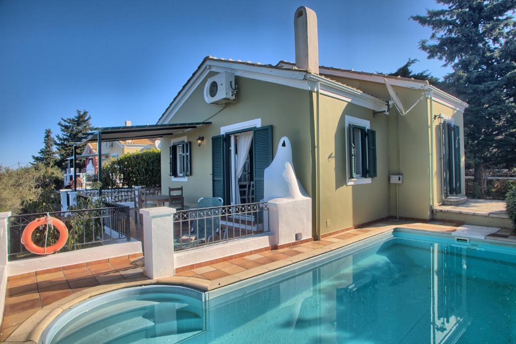 a villa with a swimming pool and a house at Villa Ostria in Tsoukalades