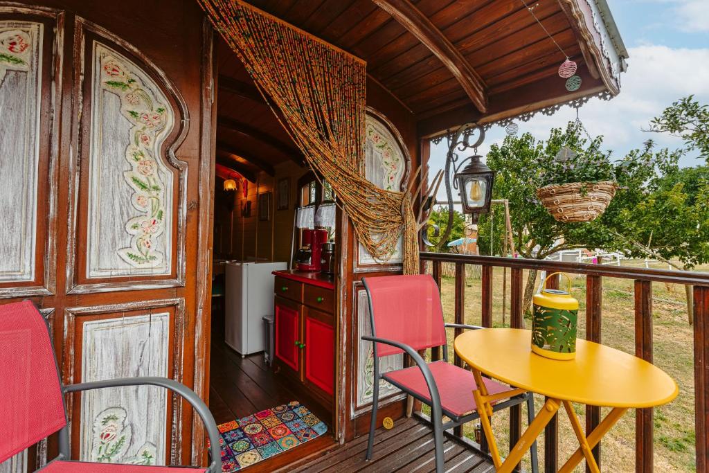 a balcony with a table and chairs on a train at Roulotte la casetta Rita in Chambon