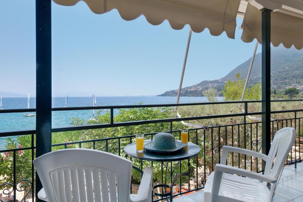 a table and chairs on a balcony with a view of the water at S7 apartment in Nikiana