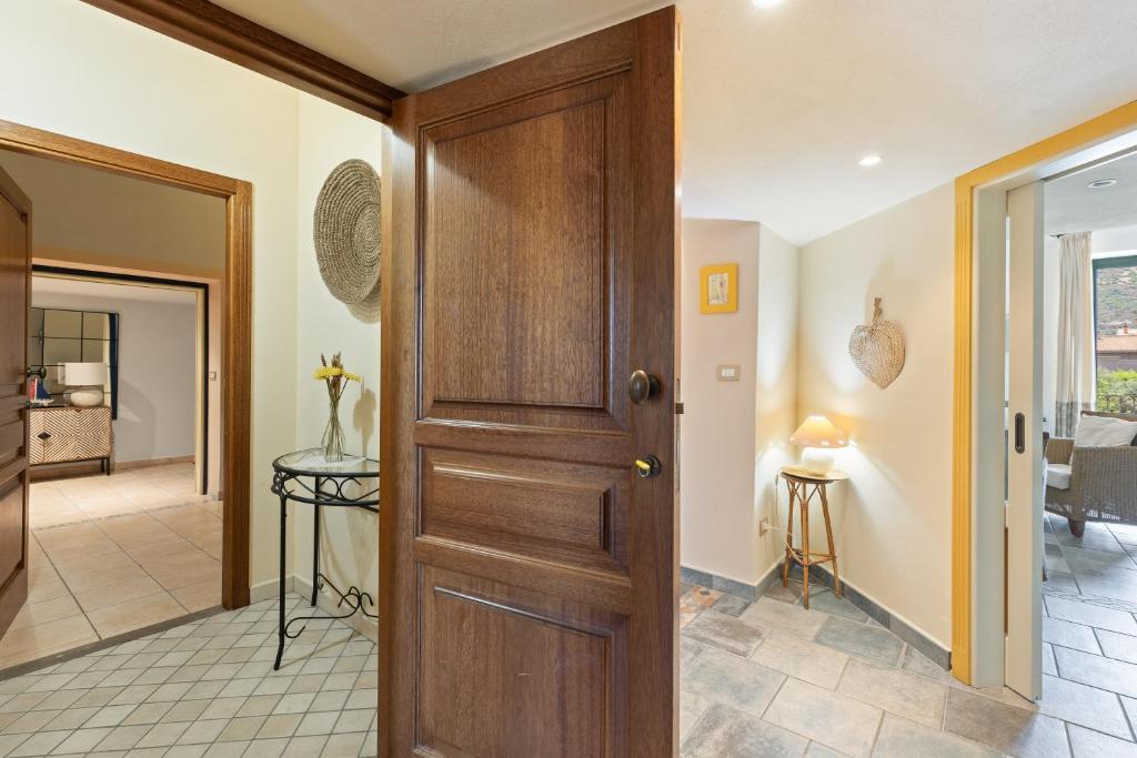 a wooden door in a room with a hallway at Le Residenze In Piazza in Bosa