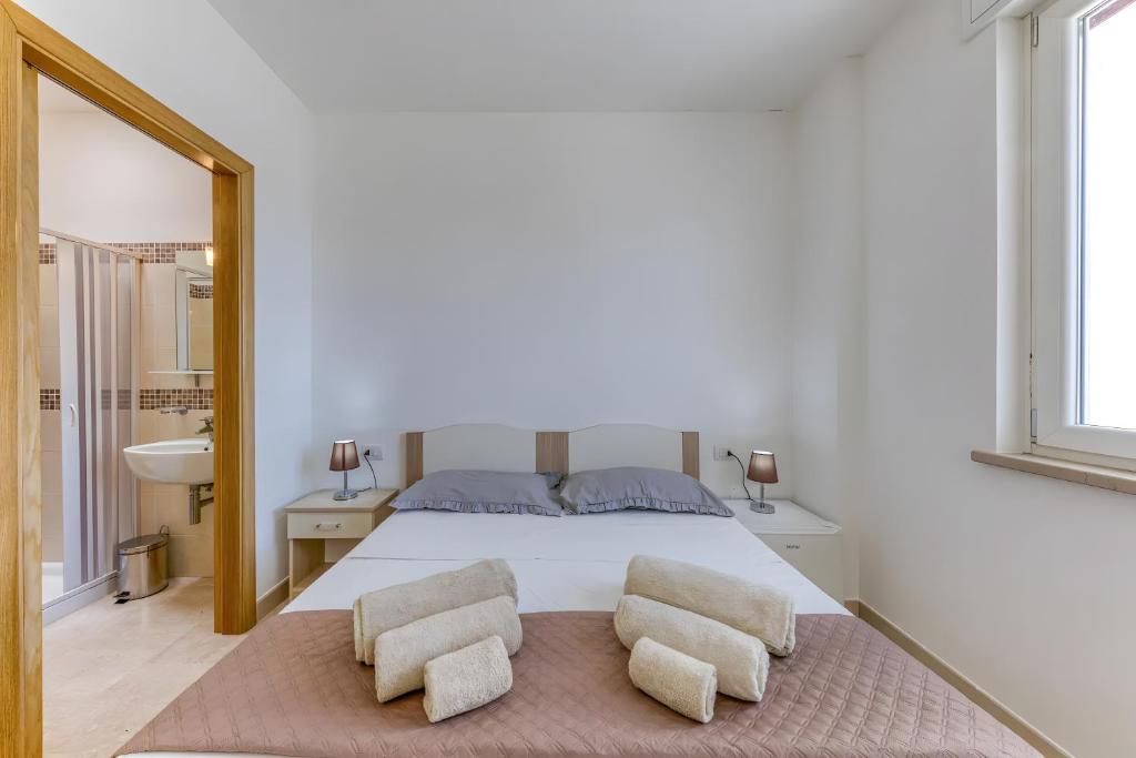 a bedroom with a bed with two chairs and a mirror at Affittacamere Arcobaleno in Torre San Giovanni Ugento