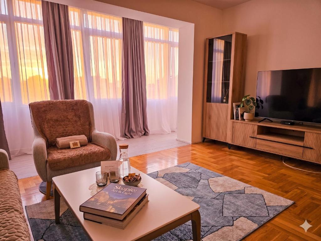 a living room with a tv and a chair and a table at Seven Tower FREE PARKING in Skopje