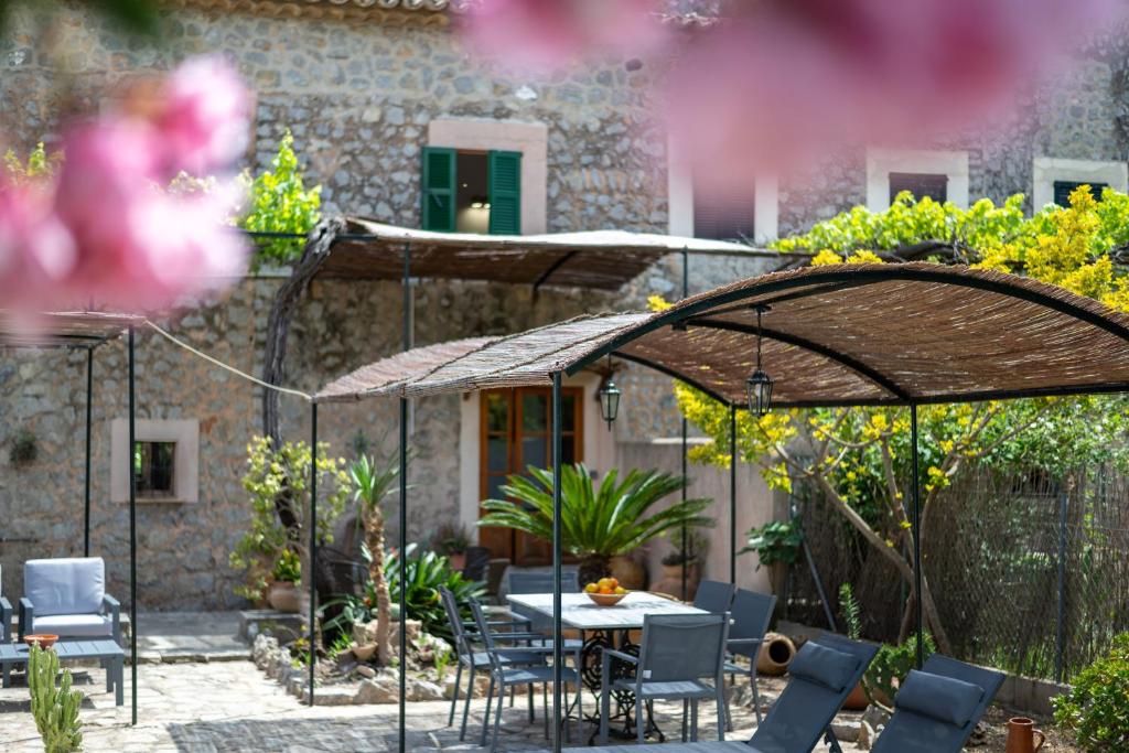 a patio with a table and chairs under an umbrella at Ca'n Repic in Port de Soller
