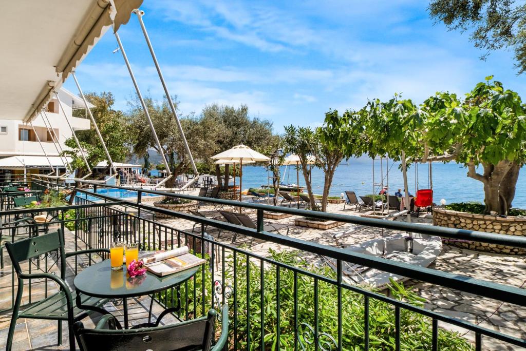 a balcony with a table and chairs next to the water at Nikiana Club - Studio 2 in Nikiana