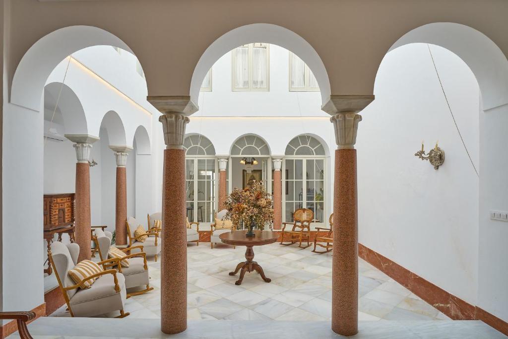 a lobby with arches and a table and chairs at Vtar Casa Palacio Vida in Espejo