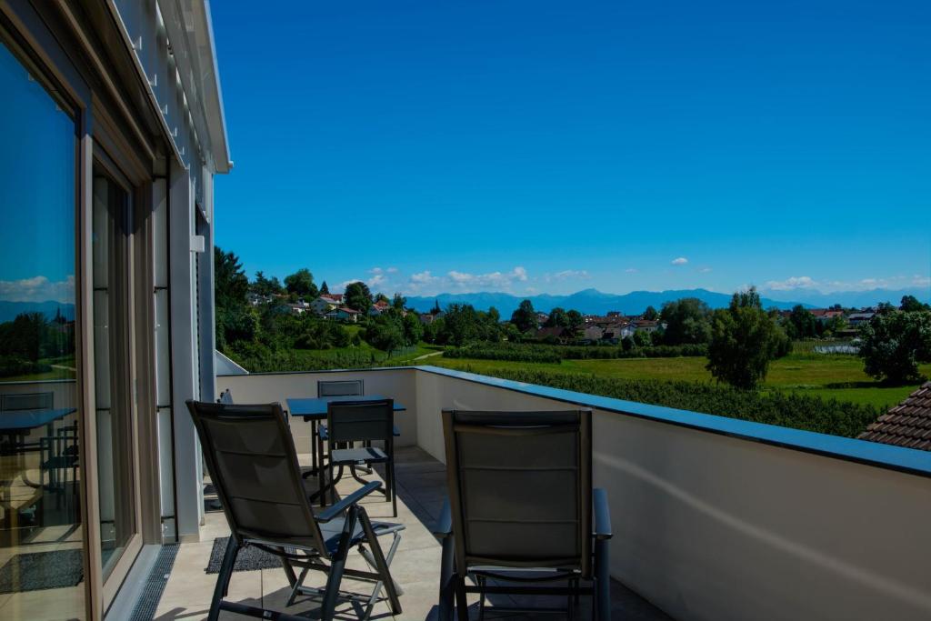a balcony with chairs and a view of the mountains at Alpenblick 3 in Lindau-Bodolz