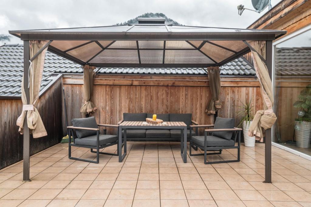 a pergola with a table and chairs on a patio at Apartment Cater Residence Bun Ste in San Vigilio Di Marebbe