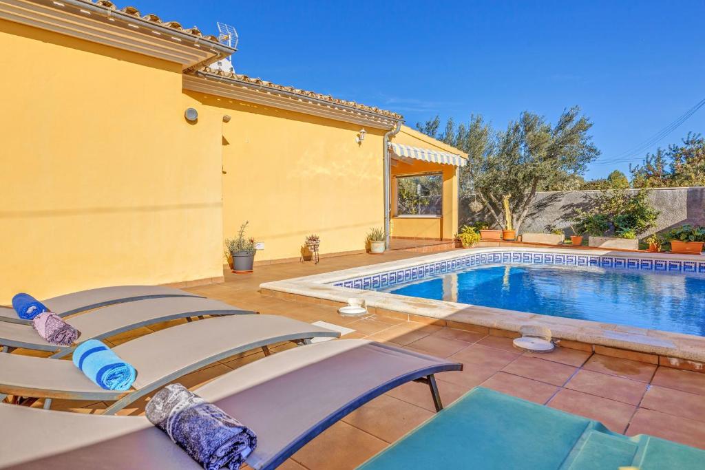 a villa with a swimming pool and two chairs at Can Parets in Santanyi