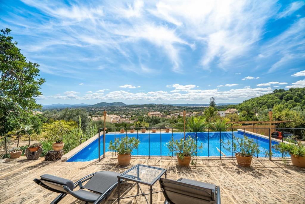 a patio with chairs and a swimming pool with a view at Can Pulit in El Port de la Selva