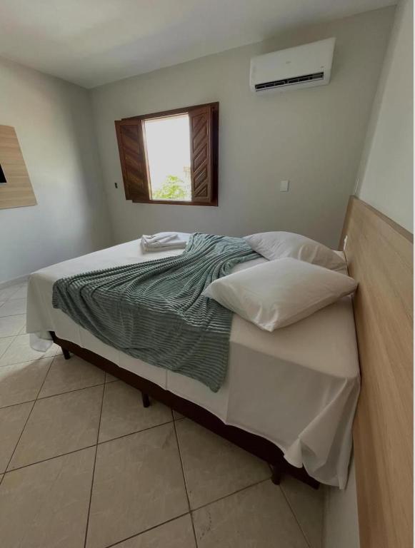 a large bed in a room with a window at Hotel Dias in Mucurici