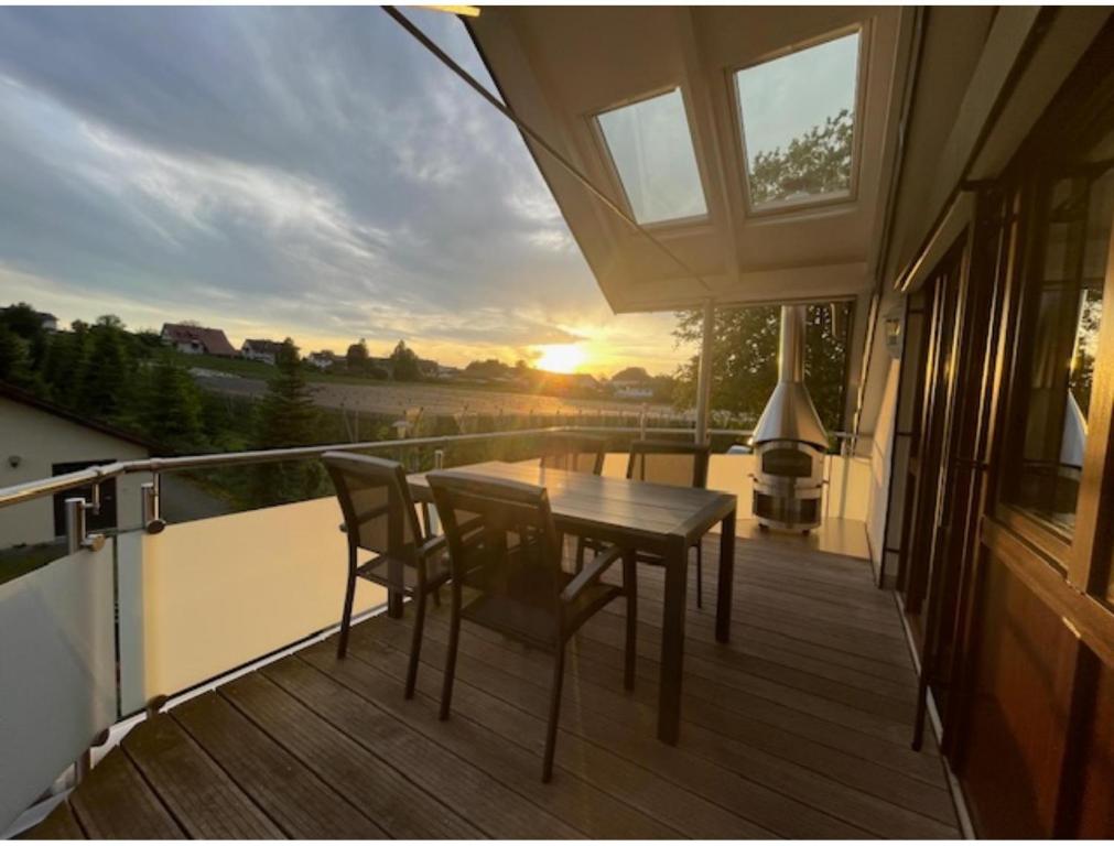a wooden deck with a table and chairs on a balcony at Ferienwohnung Zur Imme in Lindau