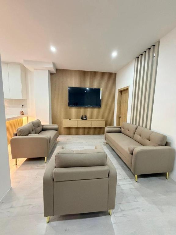 a living room with two couches and a flat screen tv at Vive Manta como nunca antes! in Manta