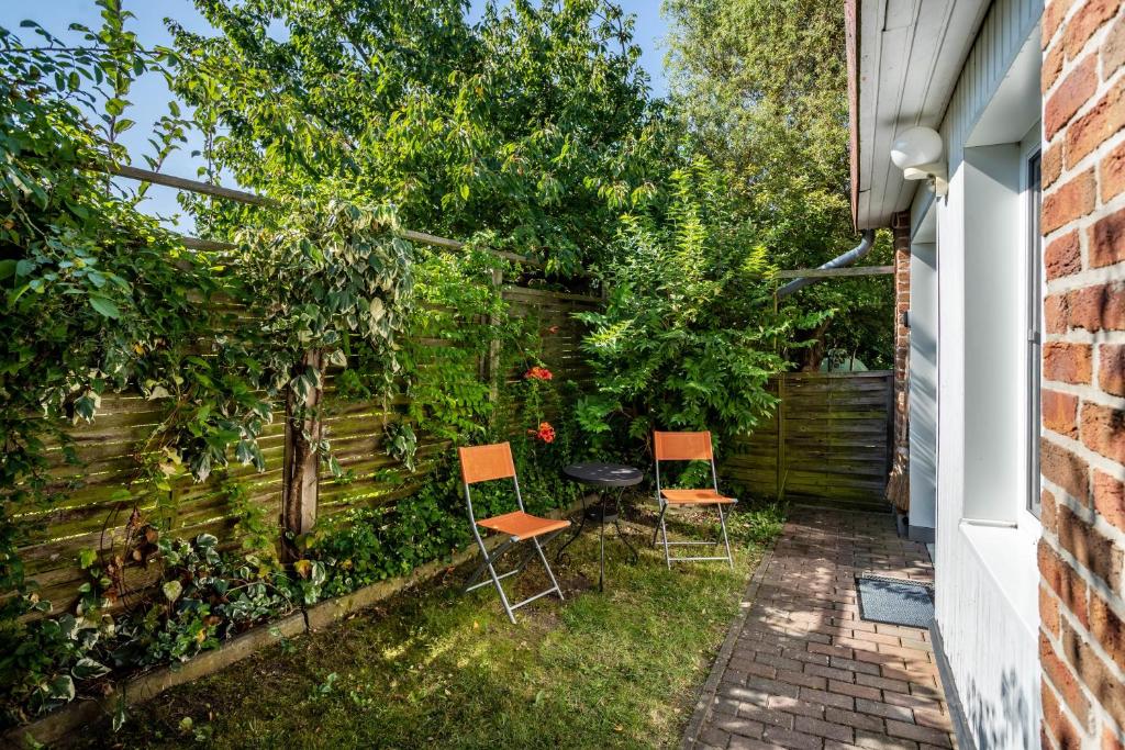 zwei Stühle und ein Tisch in einem Garten in der Unterkunft Apartment Sonnengärtchen in Blankenburg