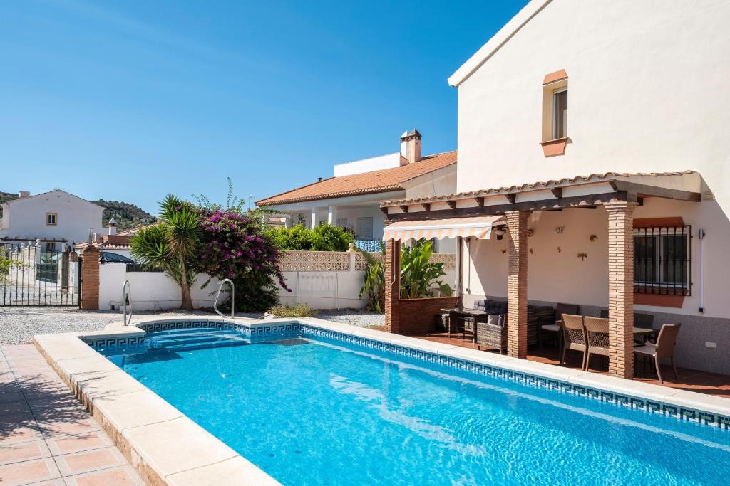 a villa with a swimming pool and a house at Villa ju-mi in El Cerro