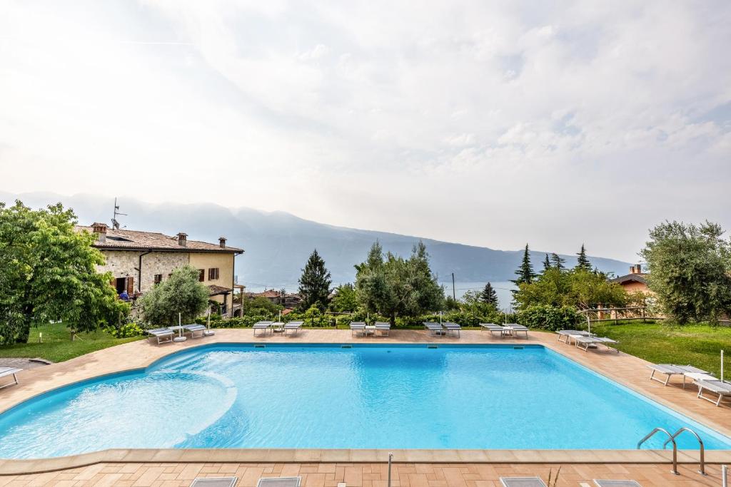 a large swimming pool with a mountain in the background at Nonna Gina in Tignale