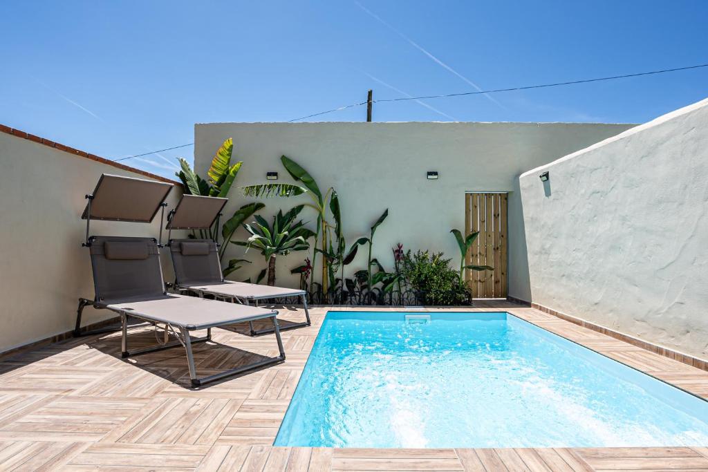 a patio with chairs and a swimming pool at Casa Dorca 1 in Conil de la Frontera