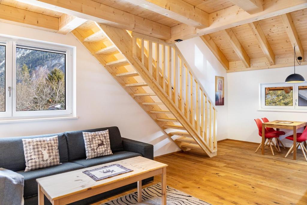 a living room with a couch and a staircase at Apartment Alte Mühle in Scharnitz