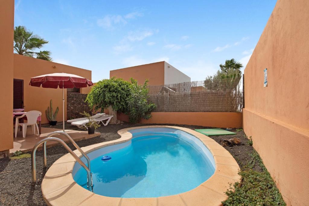a swimming pool in the backyard of a house at La Palmera de la Oliva in La Oliva