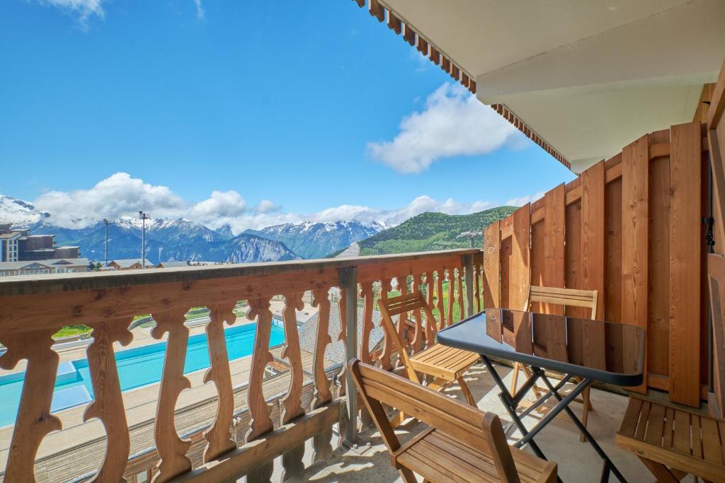 a balcony with chairs and a view of the mountains at Studio Alpe d'huez in LʼHuez