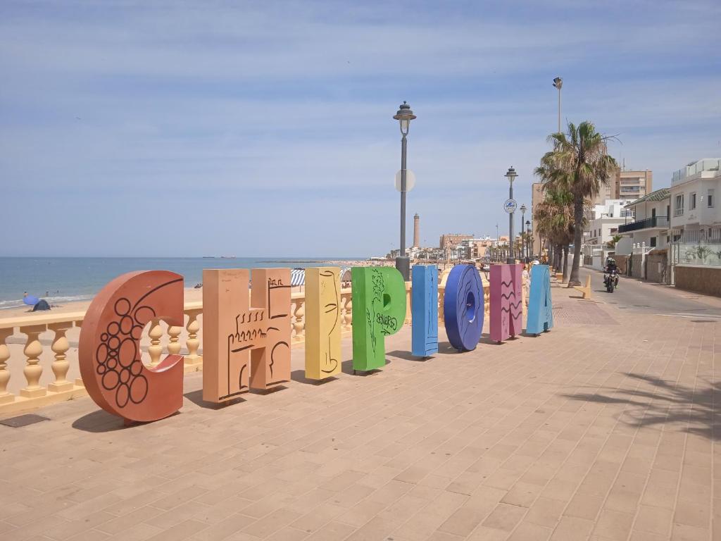 a row of different colored surfboards on a beach at Chipiona Centro y Playa in Chipiona
