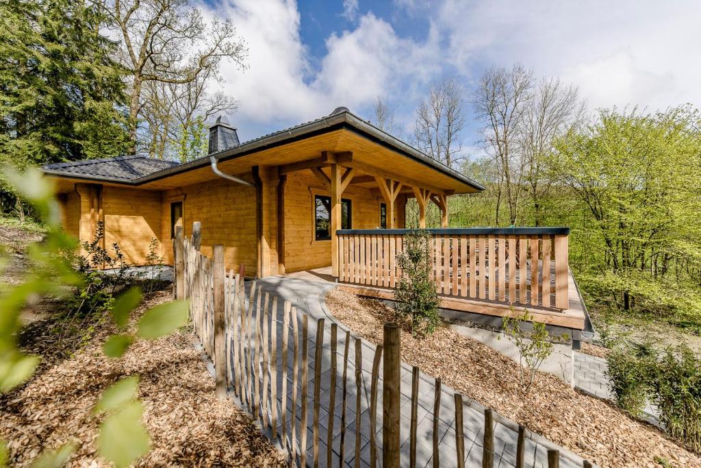 a wooden house with a fence in front of it at Blockhaus 2 in Eslohe