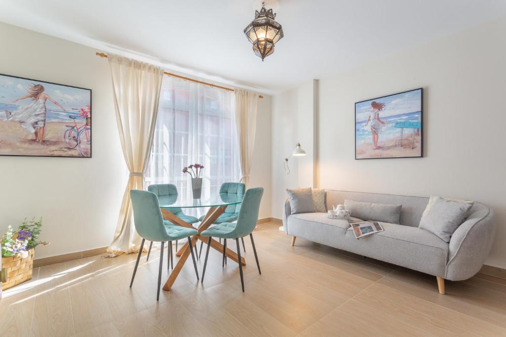 a living room with a couch and a table and chairs at Puerto Playa 3 in Puerto del Rosario