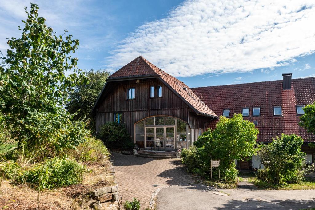 a large wooden barn with a brick building at Hof Wegwarte in Weilheim
