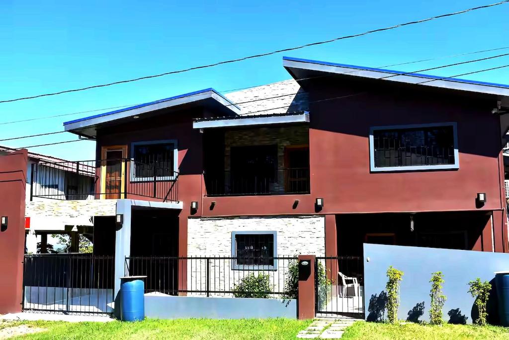 a red and black house with a fence at Lucina's in San Ignacio